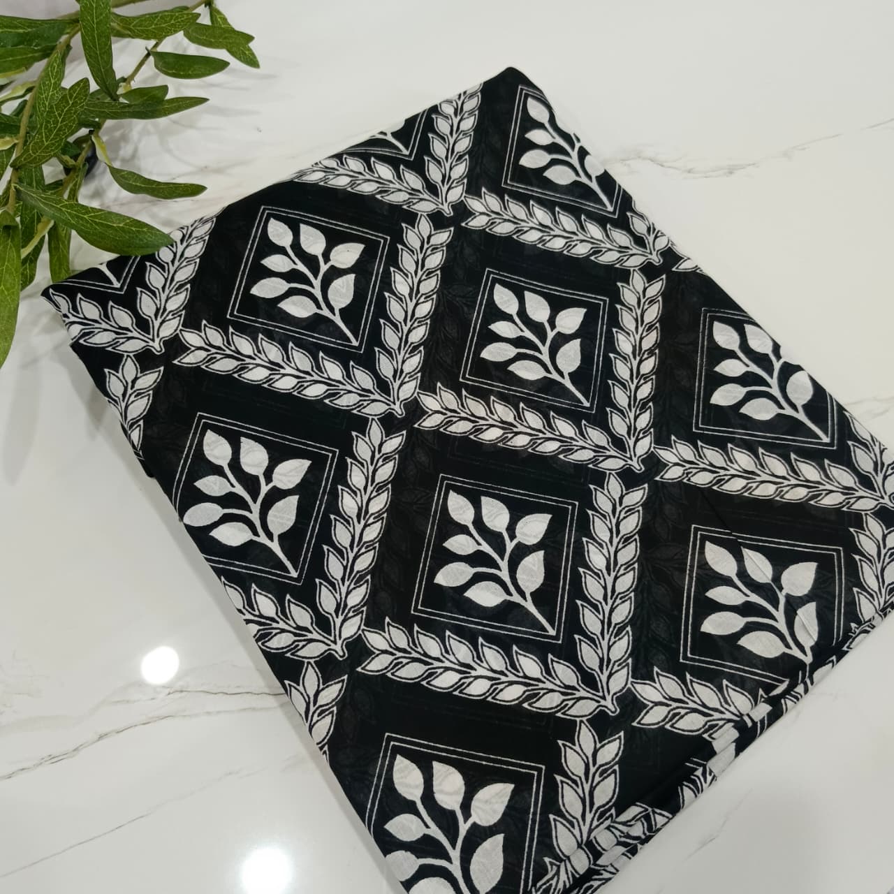 Black fabric with white geometric pattern on a white surface