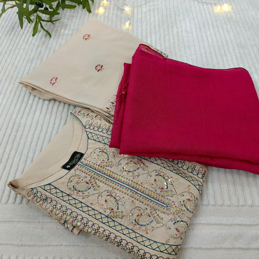 Embroidered fabric pieces on a textured surface with a plant in the corner.
Celebrate Eid with Noor-e-Zar Collection - Flat 25% Off Festive Pakistani Dresses Online