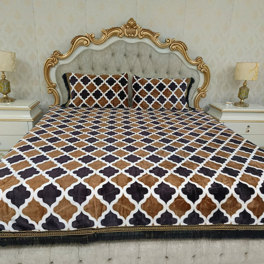 Decorative bedspread with geometric pattern on a bed with ornate headboard.