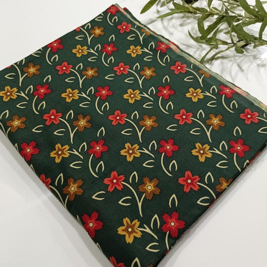Floral patterned fabric with red, yellow, and orange flowers on a green background.