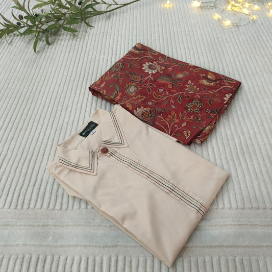 Folded beige shirt with floral patterned fabric on a textured surface