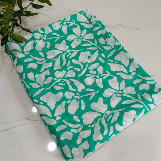 Teal fabric with white floral pattern on a marble surface