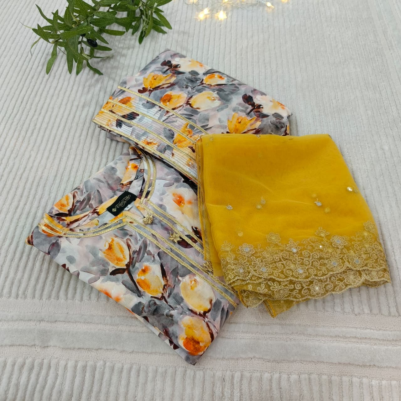 Two fabric items, one floral and one yellow with embroidery, on a textured surface.
Celebrate Eid with Noor-e-Zar Collection - Flat 25% Off Festive Pakistani Dresses Online